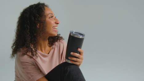 Side-Profile-Shot-of-Young-Adult-Woman-with-Flask-Having-Conversation