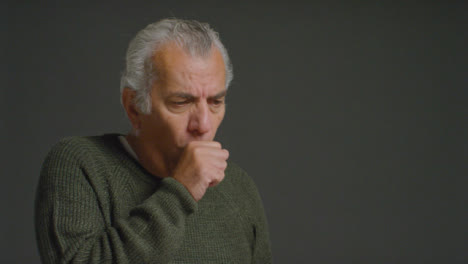 Portrait-Shot-of-a-Senior-Man-Coughing-into-His-Elbow