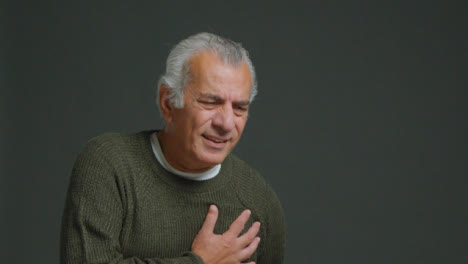 Mittlere-Aufnahme-Eines-älteren-Mannes,-Der-Seine-Hand-Vor-Schmerzen-Auf-Die-Brust-Legt