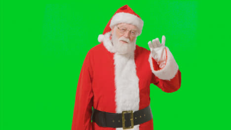 Portrait-Shot-of-Santa-Waving-Hello-to-Camera-with-a-Green-Screen