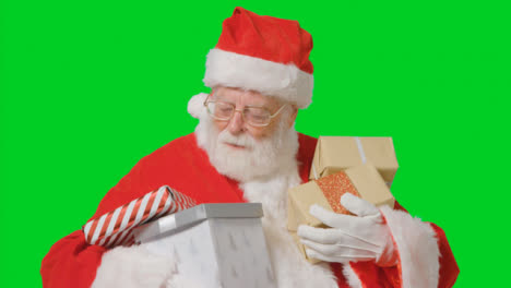 Porträtaufnahme-Des-Weihnachtsmanns,-Der-Geschenke-Vor-Dem-Grünen-Bildschirm-Hält
