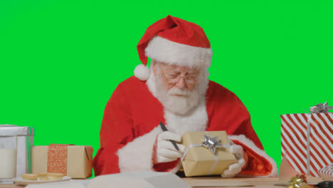 Portrait-Shot-of-Santa-Holding-Present-and-Writing-On-a-Paper-Scroll