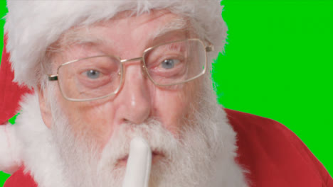Close-Up-Shot-of-Santa-Shushing-to-Camera-In-Front-of-Green-Screen