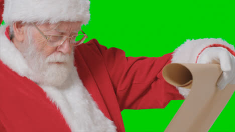 Nahaufnahme-Von-Weihnachtsmannhänden,-Die-Papierrolle-Vor-Grünem-Bildschirm-Halten