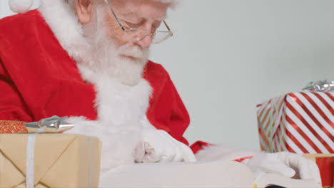 Sockelaufnahme-Des-Weihnachtsmannes,-Der-Am-Schreibtisch-Sitzt-Und-Ein-Buch-Liest