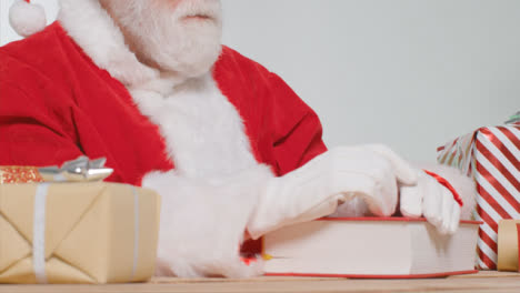 Tracking-Shot-of-Santa-Sitting-at-His-Desk-Reading-Book