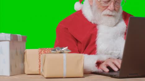 Pedestal-Shot-of-Santa-Typing-On-a-Laptop