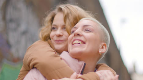 Low-Angle-Shot-of-Two-Young-Women-Hugging-and-Laughing-01