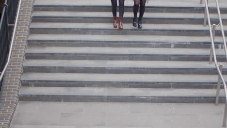 High-Angle-Shot-of-Two-Young-Women-Walking-Down-Steps