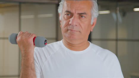 Close-Up-Shot-of-a-Senior-Man-Using-Weights-in-Gym