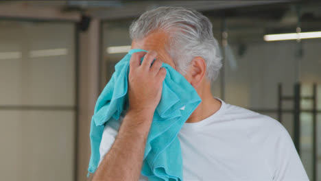 Close-Up-Shot-of-Senior-Man-Wiping-His-Brow-with-Towel