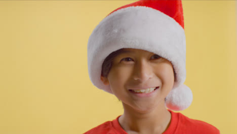 Smiling-Young-Boy-in-Santa-Hat-Jumping-