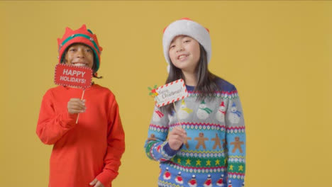 Two-Boys-Holding-Merry-Christmas-Signs-to-camera