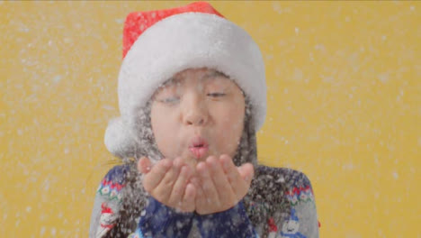 Boy-in-Santa-Hat-Blows-Snow-at-Camera
