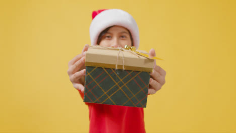 Niño-En-Traje-Festivo-Entregando-Regalo-De-Navidad-A-La-Cámara