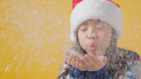Close-Up-Festive-Boy-in-Santa-Hat-Blows-Snow