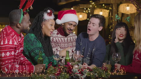 Medium-Shot-of-a-Drunk-Man-with-His-Friends-During-Christmas-Celebrations-at-Bar