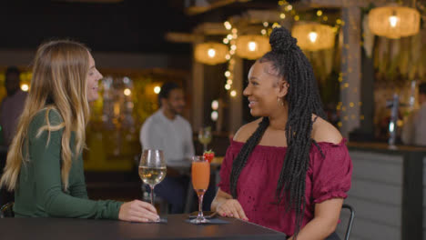 Medium-Shot-of-Woman-Joining-Another-Woman-In-a-Bar-for-Drinks