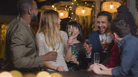 Sliding-Shot-of-Two-People-Joining-Friends-During-New-Years-Celebrations-In-a-Bar