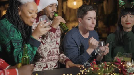 Tracking-Shot-Approaching-Drunk-Man-with-His-Friends-During-Christmas-Celebrations-at-a-Bar