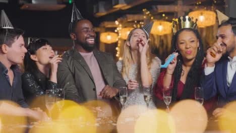 Wide-Shot-of-Friends-Celebrating-New-Year's-Eve-with-Confetti-and-Party-Blowers