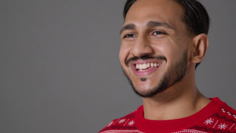 Close-Up-Shot-of-Young-Man-In-Christmas-Sweater-Saying-Merry-Christmas