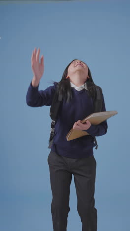 Vertical-Shot-of-a-Boy-Throwing-Paper-in-Air