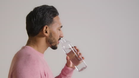 Close-Up-Side-Shot-of-a-Young-Man-Drinking-Then-Smiling