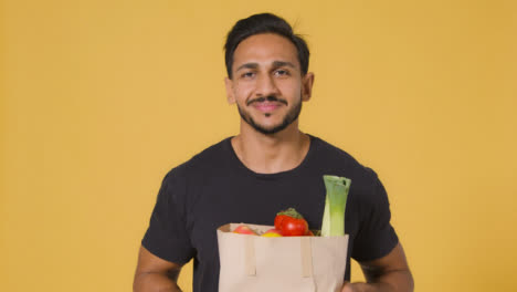 Mid-Shot-of-Young-Man-Holding-Up-Bag-of-Fruit-and-Vegetables
