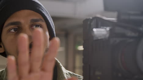 Close-Up-Shot-of-Filmmaker-Talking-and-Adjusting-Camera