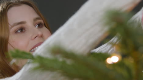 Close-Up-Shot-of-a-Young-Woman-Decorating-Christmas-Tree