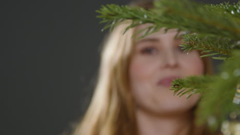 Nahaufnahme-Einer-Jungen-Frau,-Die-Christbaumkugel-Am-Weihnachtsbaum-Hängt