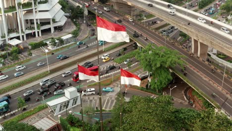Drone-Shot-Descending-On-Indonesian-Flags-Next-to-Jakarta-Highway