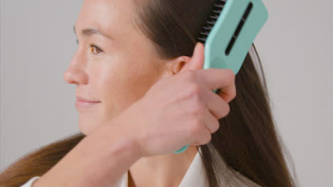 Close-Up-Shot-of-a-Woman-Brushing-Her-Hair