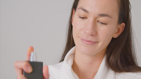 Close-Up-Shot-of-Woman-Smiling-and-Spraying-on-Perfume