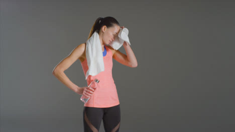 Wide-Shot-of-a-Woman-Wiping-Sweat-and-Drinking-Water-