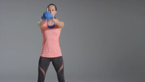 Wide-Shot-of-Young-Woman-Working-Out-with-Kettlebell