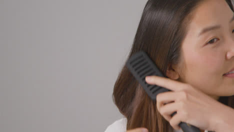Close-Up-Shot-of-Woman-Brushing-Hair-with-Copy-Space