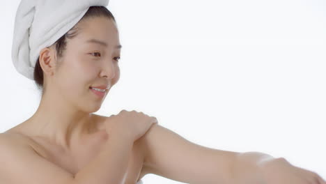 Mid-Shot-Shot-of-Young-Woman-Rubbing-Cream-into-Arms