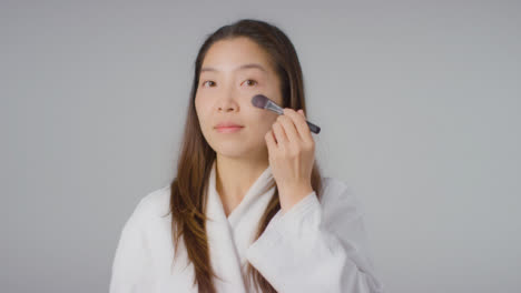 Mid-Shot-of-Young-Woman-Applying-Foundation