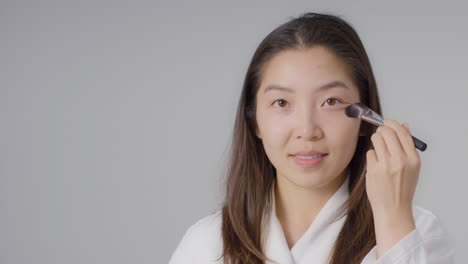 Mid-Shot-of-Young-Woman-Applying-Foundation-with-Copy-Space