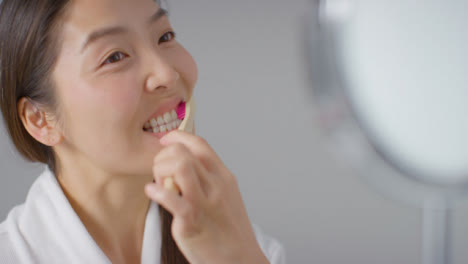 Close-Up-Shot-of-Woman-Brushing-Teeth-and-then-Smiling