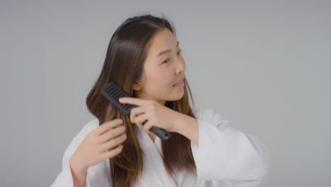Mid-Shot-of-Woman-Smiling-and-Brushing-Hair