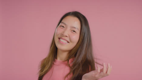Close-Up-Shot-of-Woman-In-Pink-Smiling-and-Dancing-to-Camera