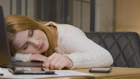 Tracking-Shot-of-Young-Woman-Asleep-at-Work
