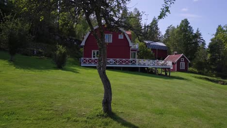 Pan-of-Swedish-Red-Barn-House-Through-Trees