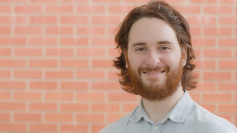 Portrait-Shot-of-Young-Man-In-Front-of-Brick-Wall