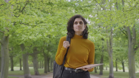 Tracking-Mid-Shot-of-Female-Student-Walking-Through-Tree-Lined-Path