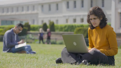 Halbe-Aufnahme-Einer-Studentin,-Die-Im-College-Park-Auf-Einen-Laptop-Schaut