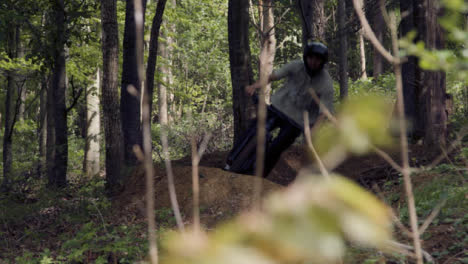 Slow-Motion-Shot-Of-Man-On-Mountain-Bike-Cycling-Along-Dirt-Trail-Through-Woodland-2